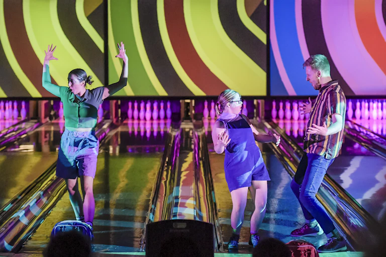 Three dancers on a bowling ally.
