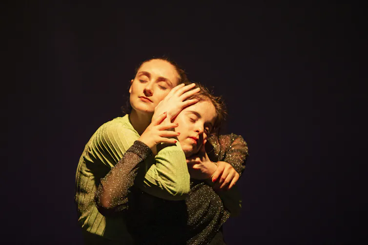 Two women embrace.