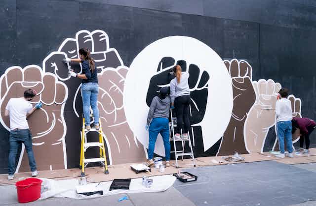 A group of people painting a wall mural