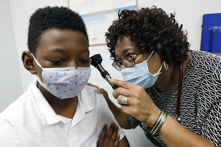 A doctor examines a young boy.