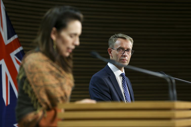 Ashley Bloomfield and Jacinda Ardern speaking at lecturns