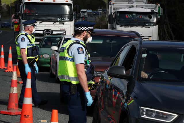 Police officers wearing masks stopping motor vehicles