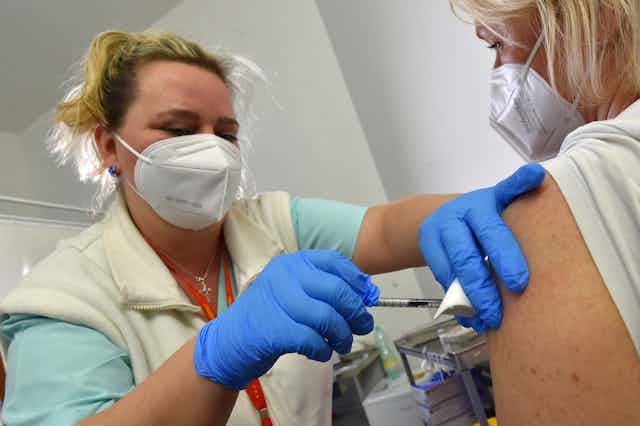 Health-care worker giving someone a COVID vaccine