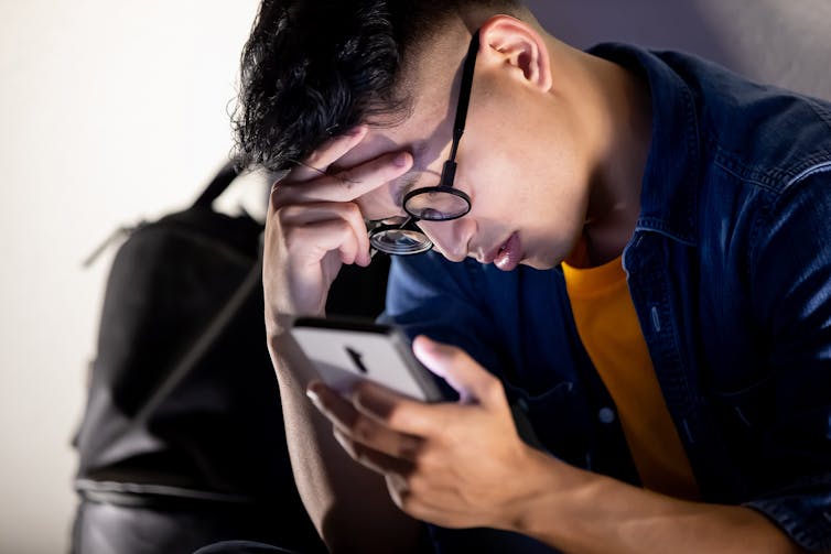 Young man upset by a message on his phone