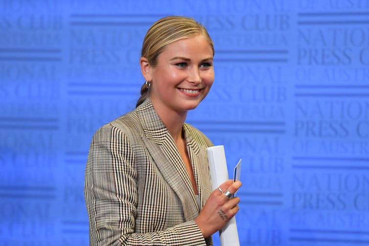 young blonde woman at National Press Club podium