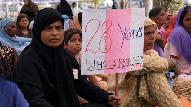 Mujer con pancarta protestando por el desastre de Bhopal (India)