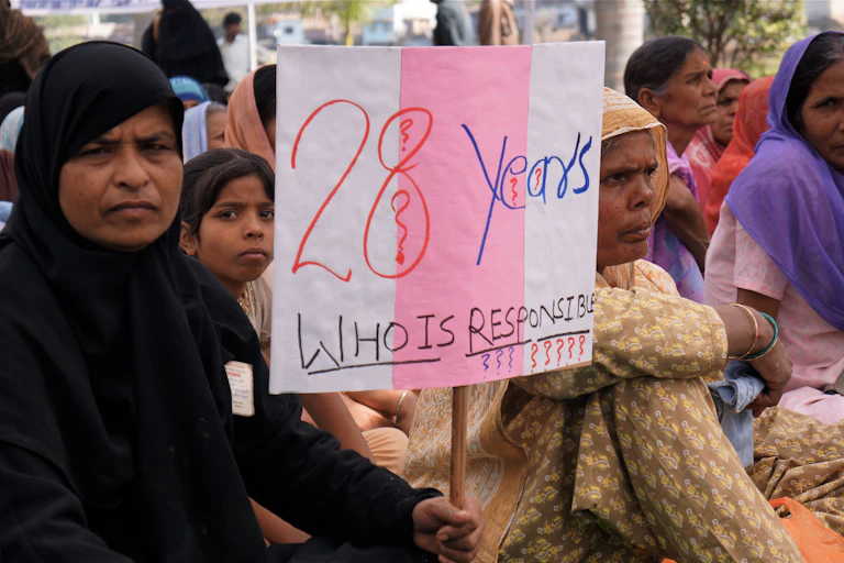 Mujer con pancarta protestando por el desastre de Bhopal (India)