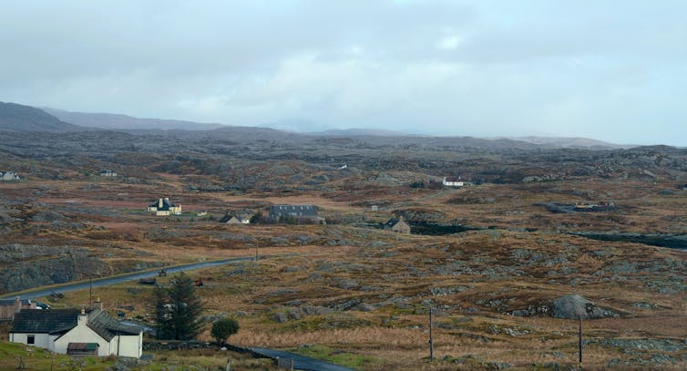 A wet and windswept landscape dotted with homes.