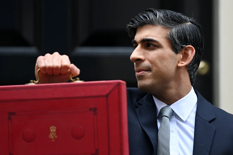Rishi Sunak holding up the red briefcase outside 11 Downing Street
