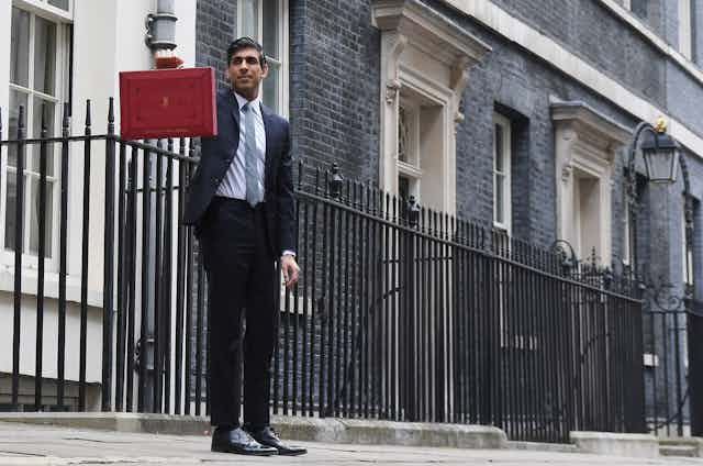 Rishi Sunak holding up the red briefcase outside 11 Downing Street