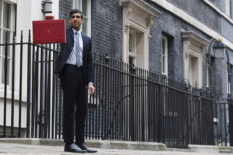 Rishi Sunak holding up the red briefcase outside 11 Downing Street