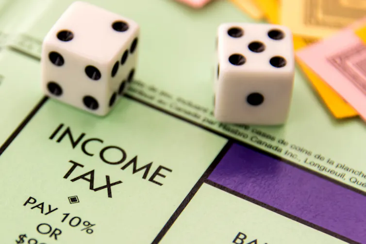 Dice scoring a seven on a Monopoly board above Income Tax square