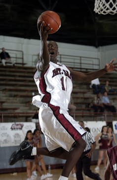 A basketball player attempts to go for a slam-dunk.