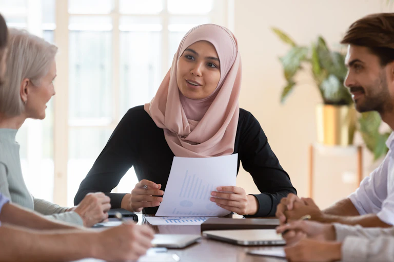 young muslim woman talking with diverse group of colleages