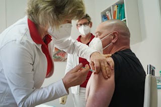 A health worker in Germany being vaccinated with the Oxford/AstraZeneca vaccine