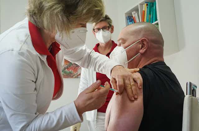 A health worker in Germany being vaccinated with the Oxford/AstraZeneca vaccine