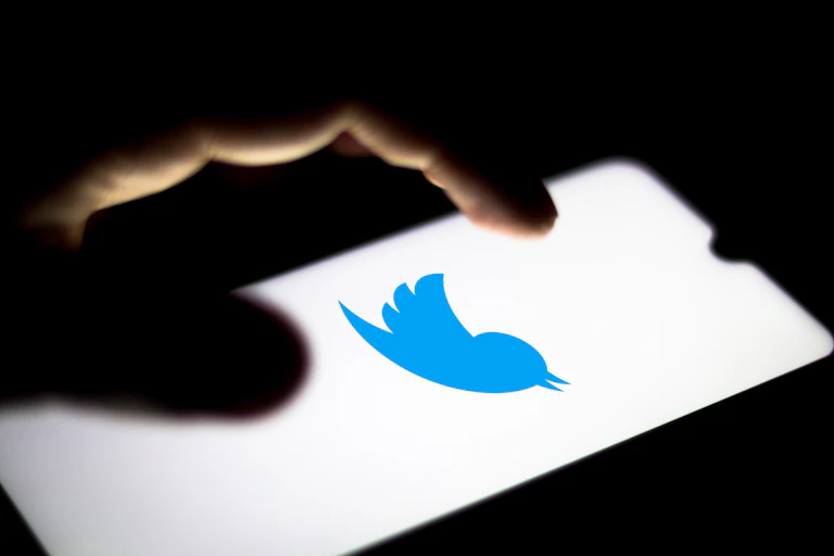 A hand hovers over a Twitter screen
