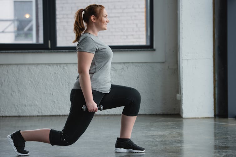 Woman performing lunges while holding dumbbells.
A combination of behavioural psychology measures like goals may keep you motivated and help you lose weight.