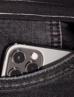 An iphone in a jeans pocket
