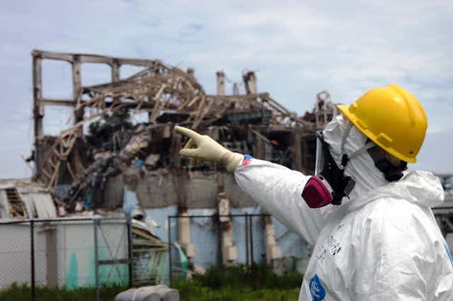 Researcher in protective suit with helmet and respirator .