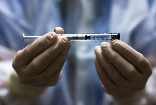 A clinician holds a Johnson and Johnson vaccine syringe
