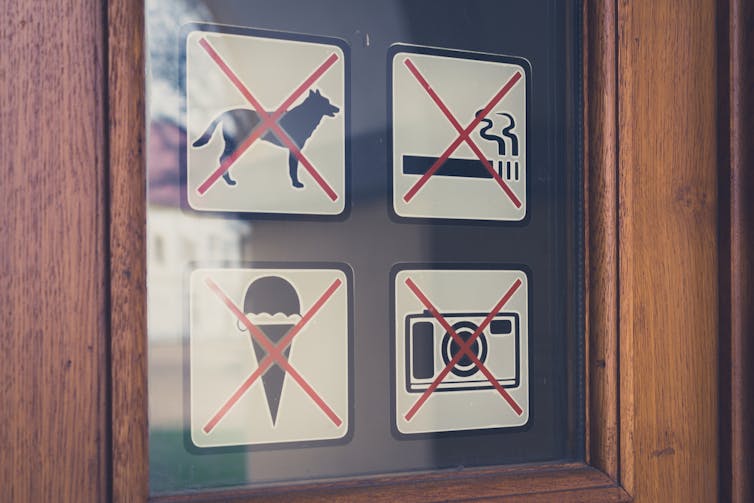 Sign on a door refusing dogs entry.