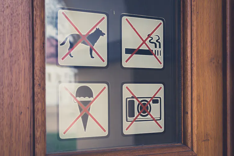 Sign on a door refusing dogs entry.