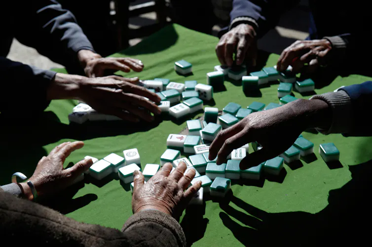 A majong game underway but only players' hands can be seen.