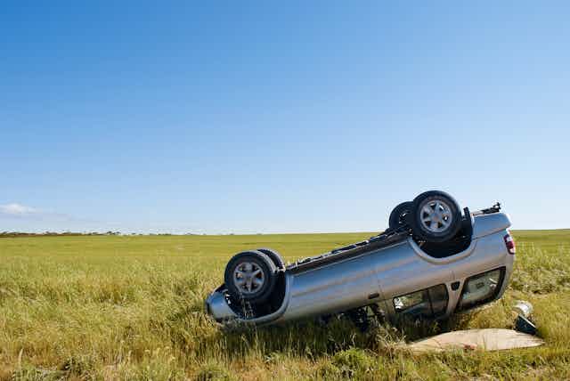 a car flipped over onto its hood in a rural areas