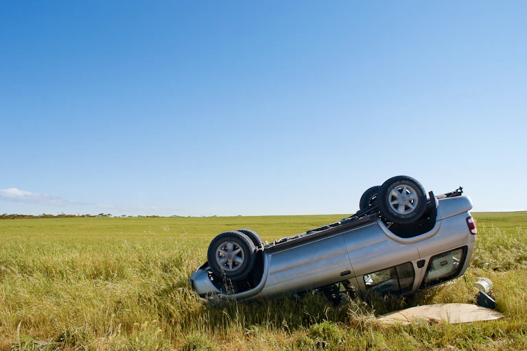 a car flipped over onto its hood in a rural areas