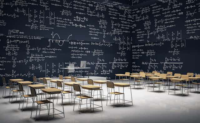 Study desks in a room with mathematical equations on the walls