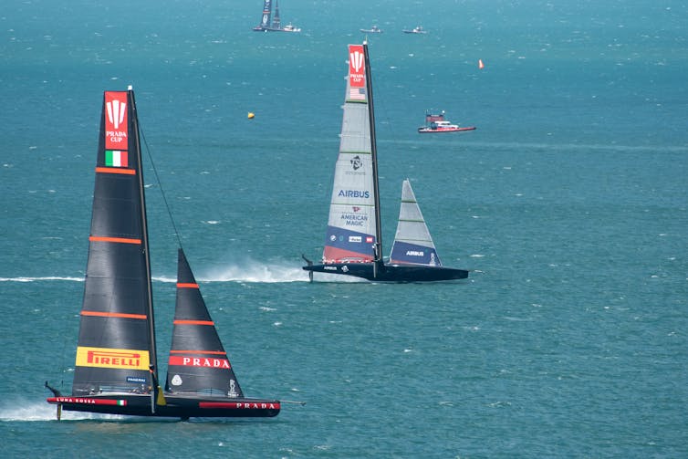 The two yacht at speed race across the harbour route.