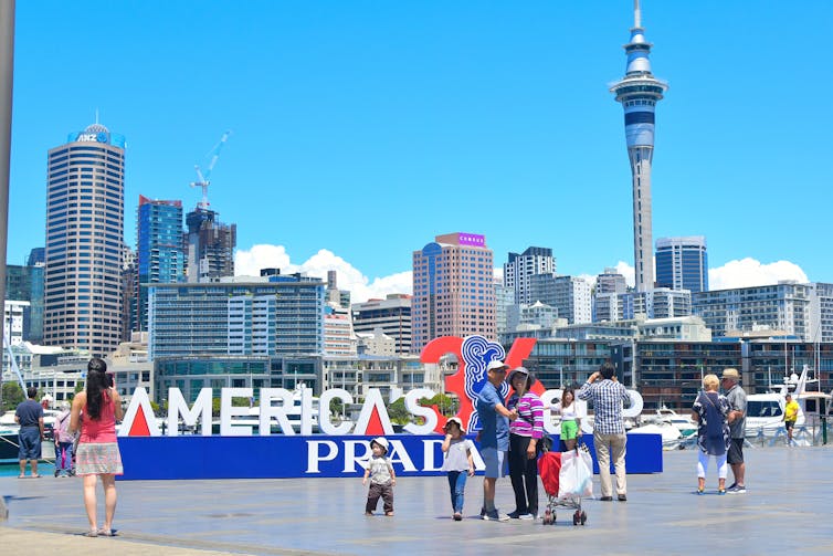 People taking photos at America's Cup sign on Auckland's waterfront.
