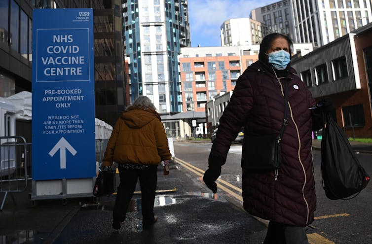 People entering and leaving a COVID-19 vaccination centre