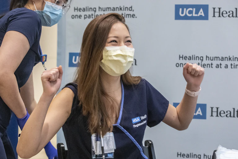 A nurse looks happy after receiving the COVID-19 vaccine.