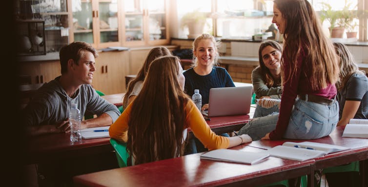 Students in classroom talking.