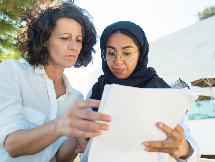 Two women read a document