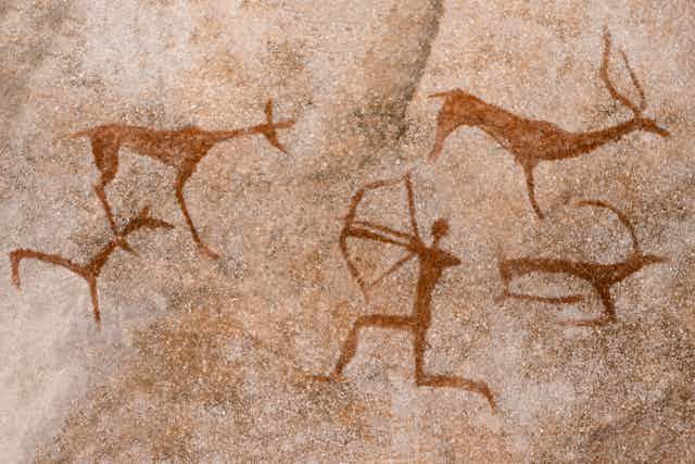 Cave drawing of an archer shooting at animals