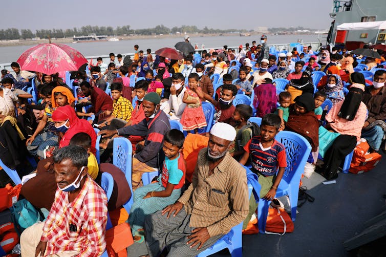 Rohingya refugees sit on a crowded ship