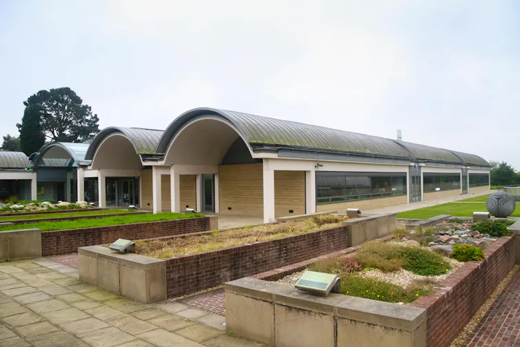 Series of domed buildings with flowerbeds in foreground.