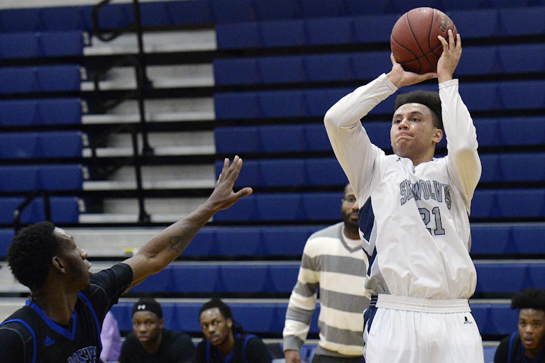 A basketball player attempts to throw a ball during a game.