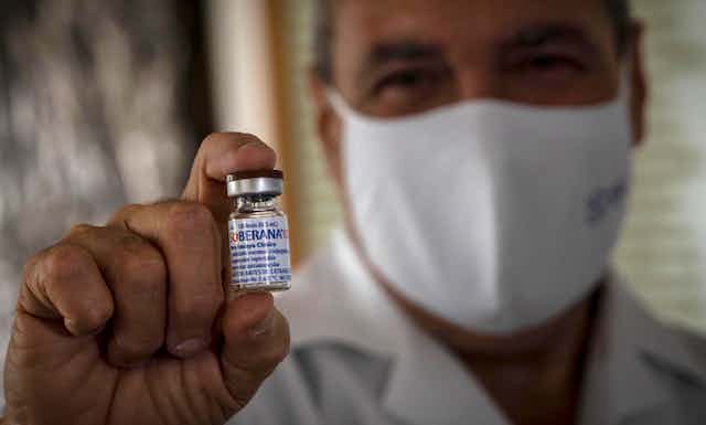 A doctor shows an empty vial of the experimental Soberana 02 vaccine