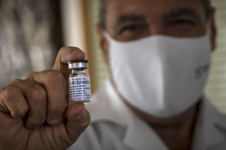 A doctor shows an empty vial of the experimental Soberana 02 vaccine