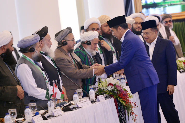 Presiden Joko Widodo (kedua kanan) didampingi wakil presiden saat itu Jusuf Kalla menyalami sejumlah ulama yang mengikuti pertemuan trilateral ulama Afganistan, Indonesia dan Pakistan di Istana Bogor, Jawa Barat, pada 2018.