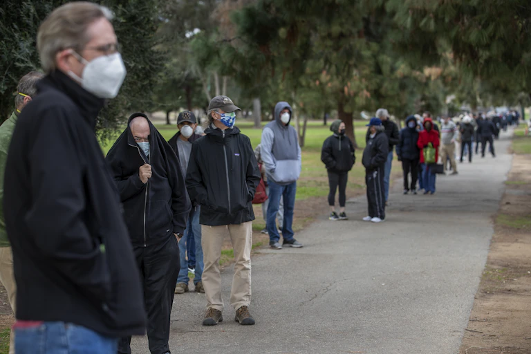 A long line of people queue for vaccines in California