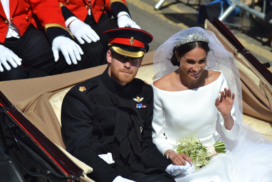Prince Harry and Meghan in wedding outfits riding in carriage