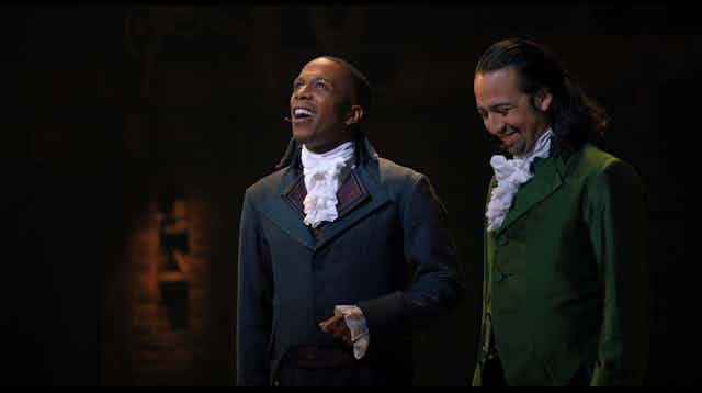 Two characters from Broadway show Hamilton stand together onstage