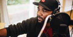 A man records an album next to a microphone.