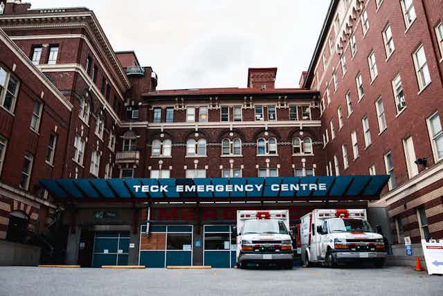 Exterior of St. Paul's Hospital with ambulances in foreground