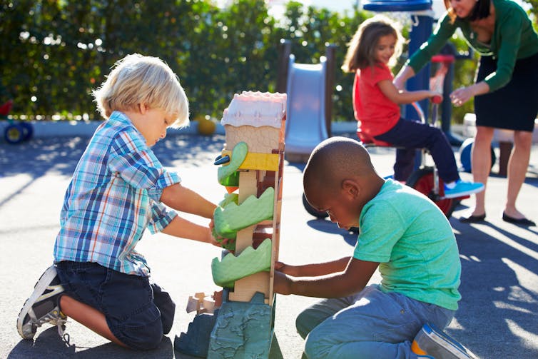 young children playing with a toy in a playground